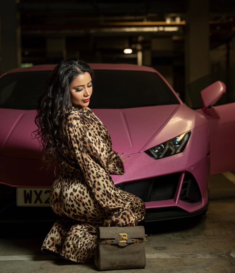 Model posing in leopard outfit beside pink Lamborghini, captured by Fred Art Studio
