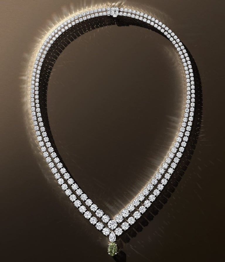 De Beers diamond necklace with green gemstone pendant.