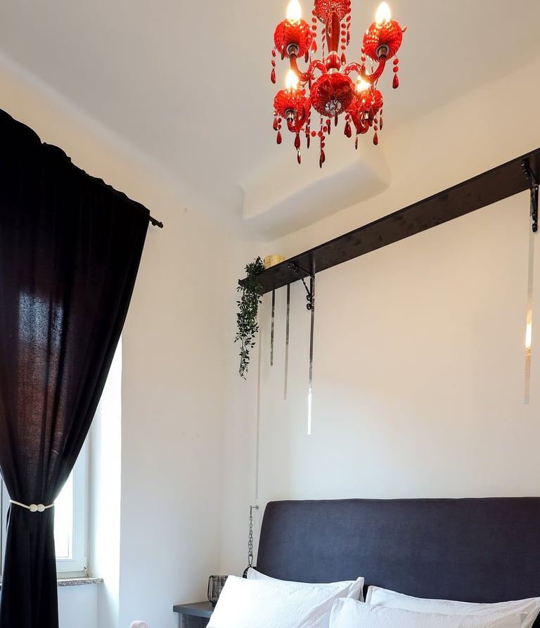 The photo shows honeymoon special setting of the bedroom in the BDSM Love Apartment. Champagne, rose petals, restraints.