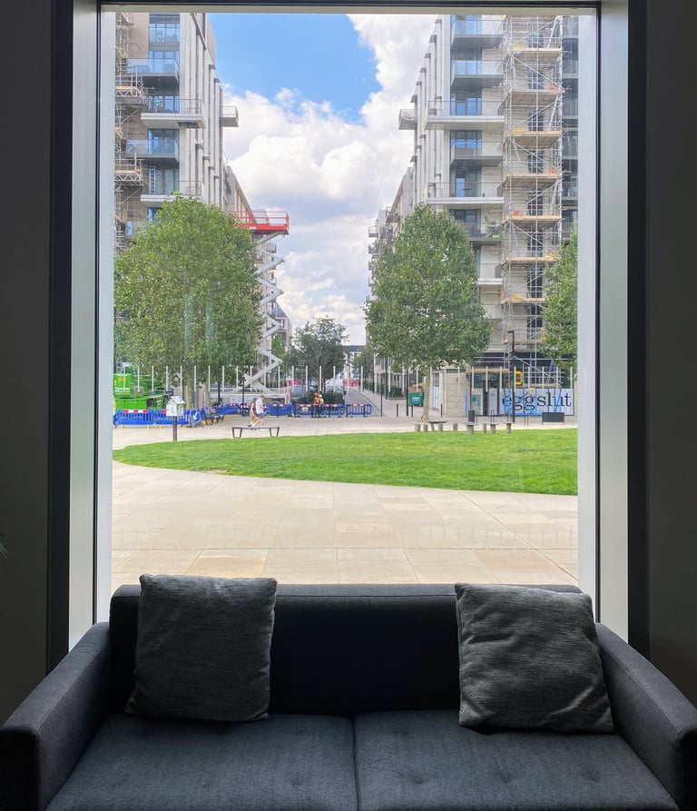 View from a window with window seat overlooking the park and other tall buildings 