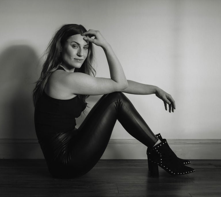 a woman in black and white photo of a woman in leather pants and boots
