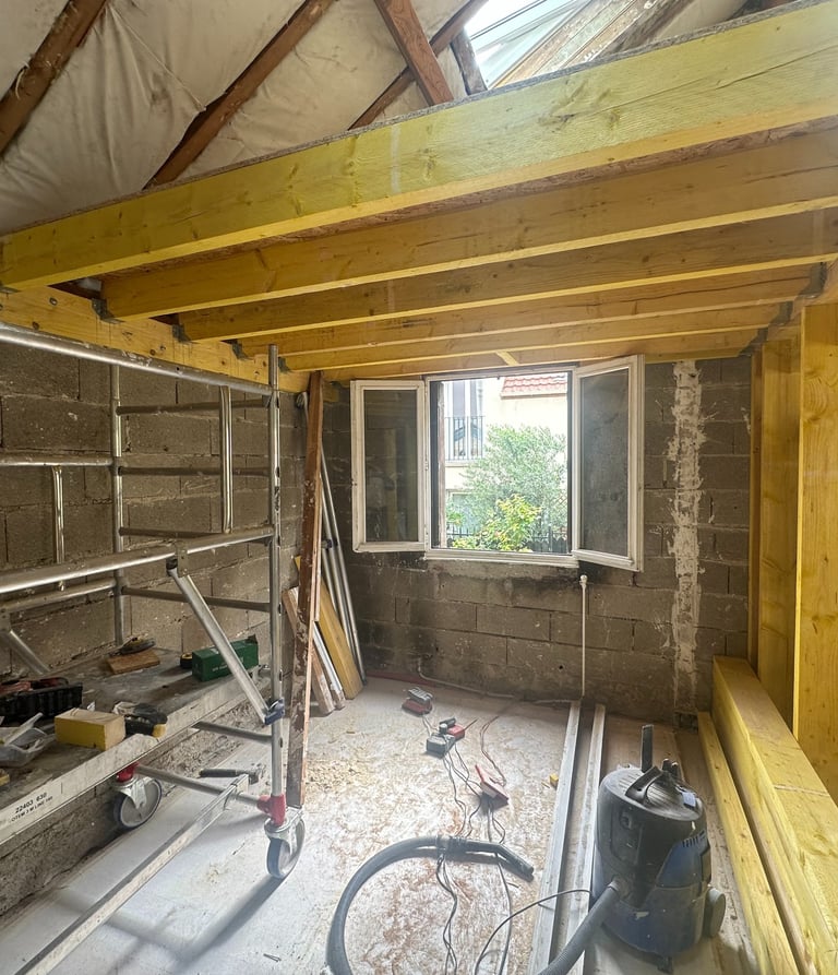 a lofted room under renovation works with large wood structure