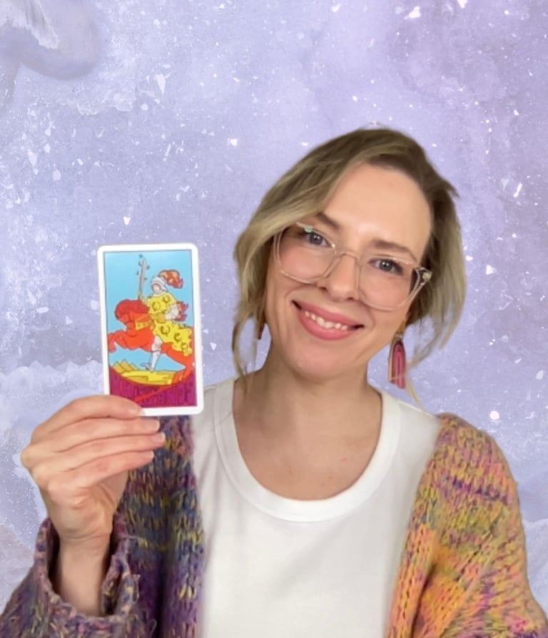 Natalie Grace, Founder of Crystal Aura Tarot, holding the Knight of Wands tarot card