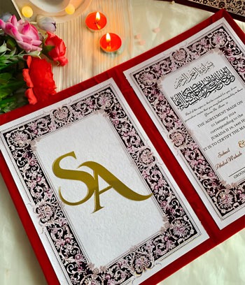 a wedding invitation card with a gold monogramming