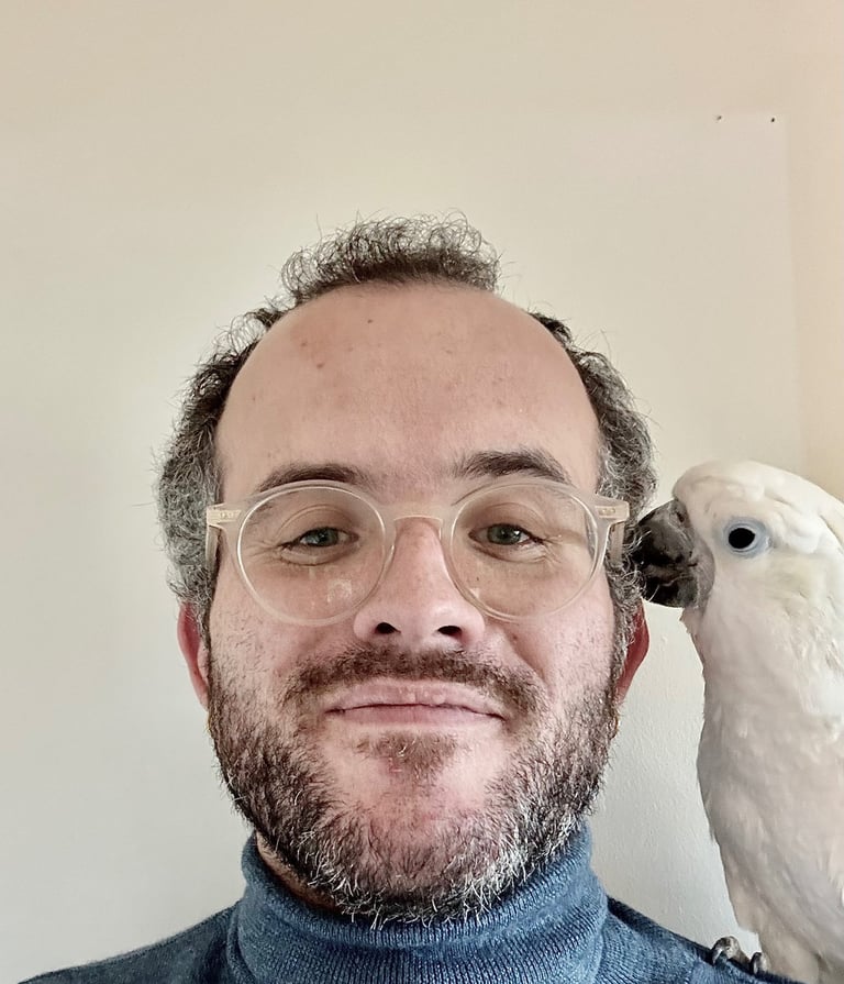 a man with glasses and a parrot on his head