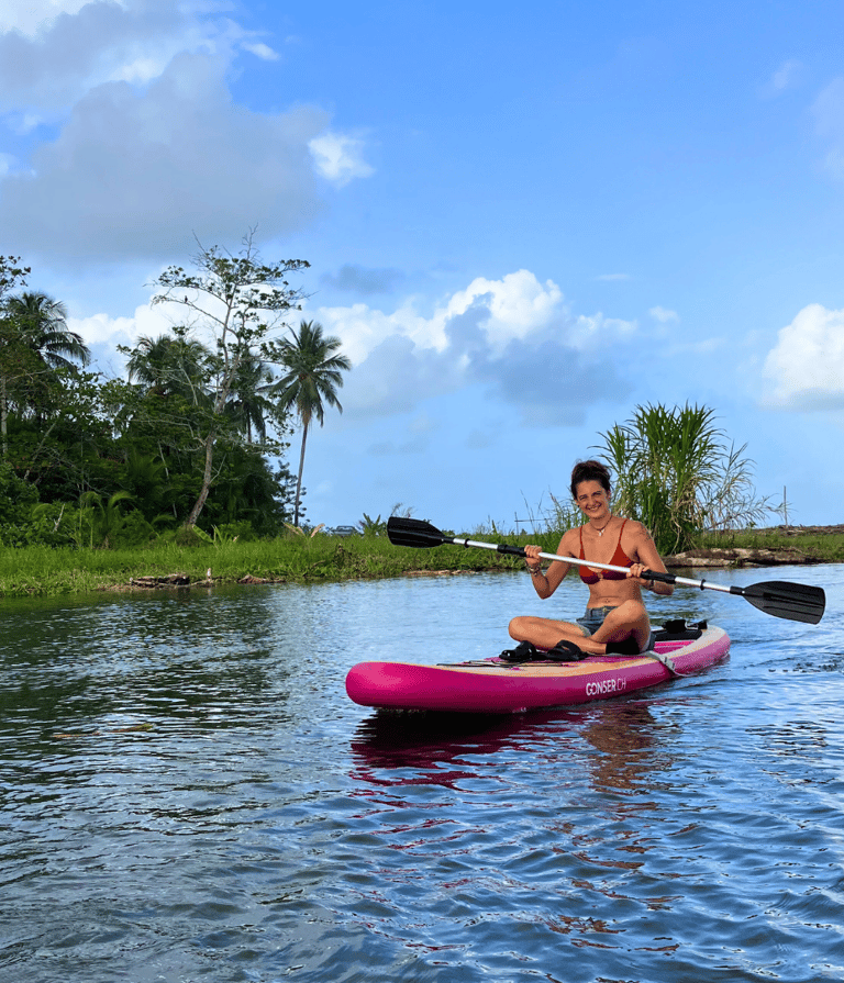 A girl smiles at the camera during a standup paddle board tour with camping babsita caribbean coast