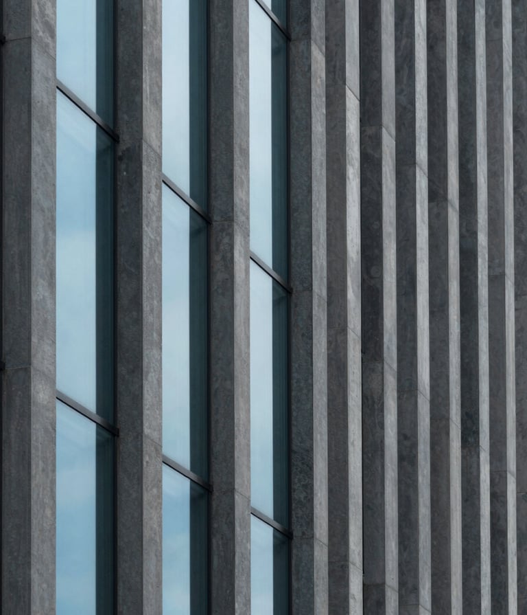 A minimalist architectural detail of a modern South American building facade. Clean vertical lines in dark grey concrete contrasted with soft baby blue glass windows. Professional photography, natural overcast light, focus on geometric shadows and textures.