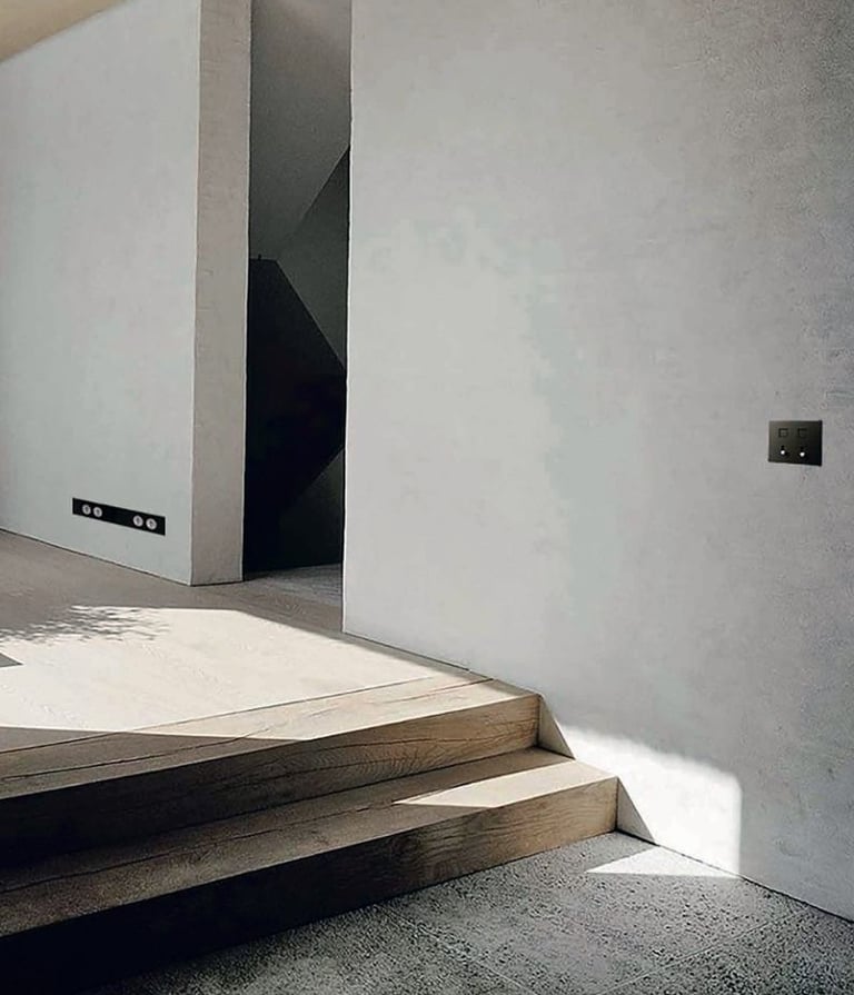 Espacio de diseño con interruptores negros integrados en pared clara y arte contemporáneo