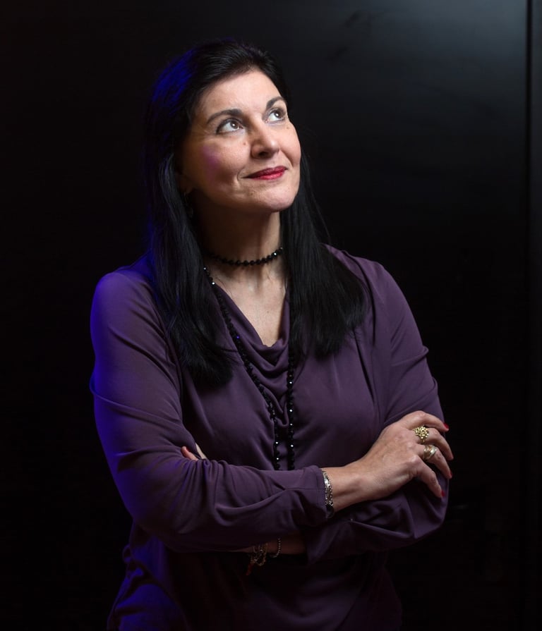 Ritratto della giornalista Clara Mennella, specializzata in food & wine, con sguardo verso l’alto su sfondo scuro.