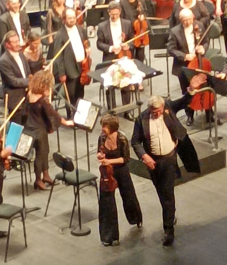 The conductor, accompanied by lead violinist .