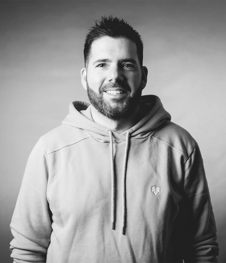 Portrait paysage de Cyril Steau, photographe à Paris, en studio noir et blanc avec éclairage doux et expression naturelle.