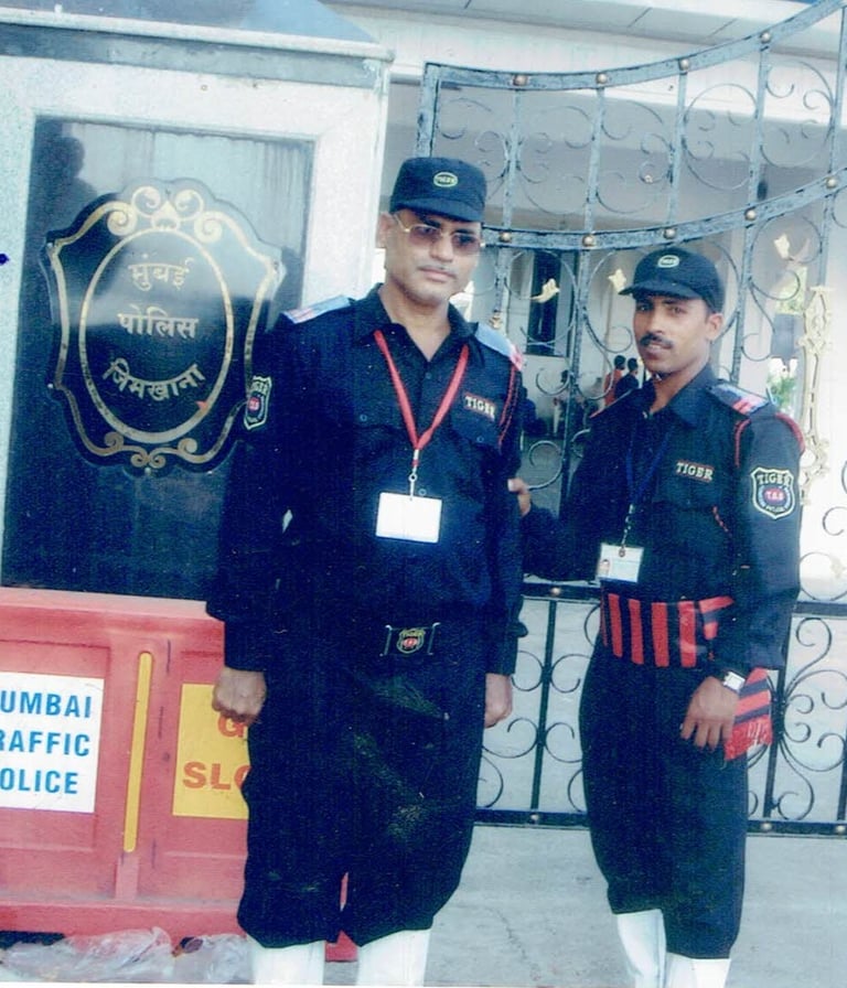 two men in uniform uniforms standing in front of a gate