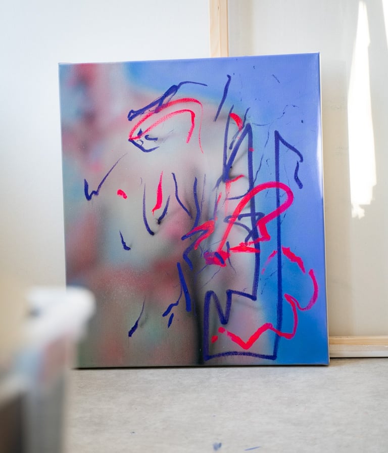 Contemporary abstract canvas art with blue spray paint and neon red gestural lines on an easel.