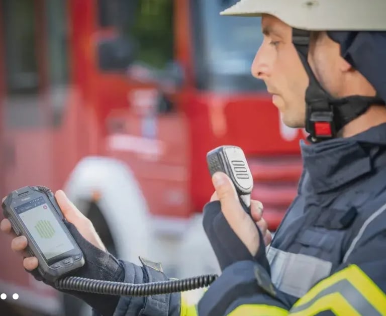 Firefighter using microphone/speaker connected to his PoC radio