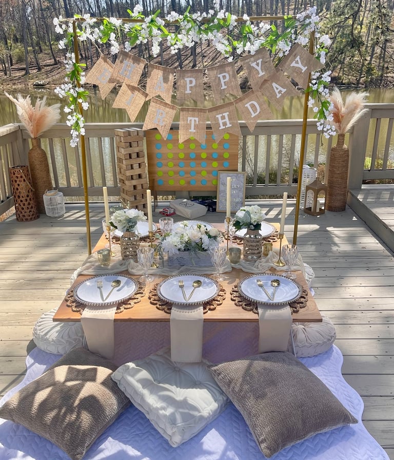 Outdoor neutral birthday party setup elevated picnic rental service with layered place settings