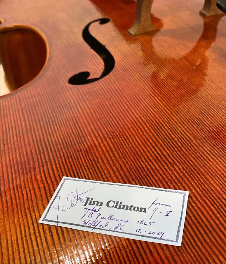 Cello top plate with Jim Clinton label laying on top before installation