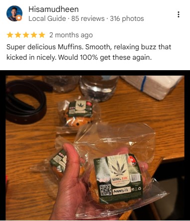 A hand holding a 50mg THC cannabis infused muffin in clear plastic packaging.