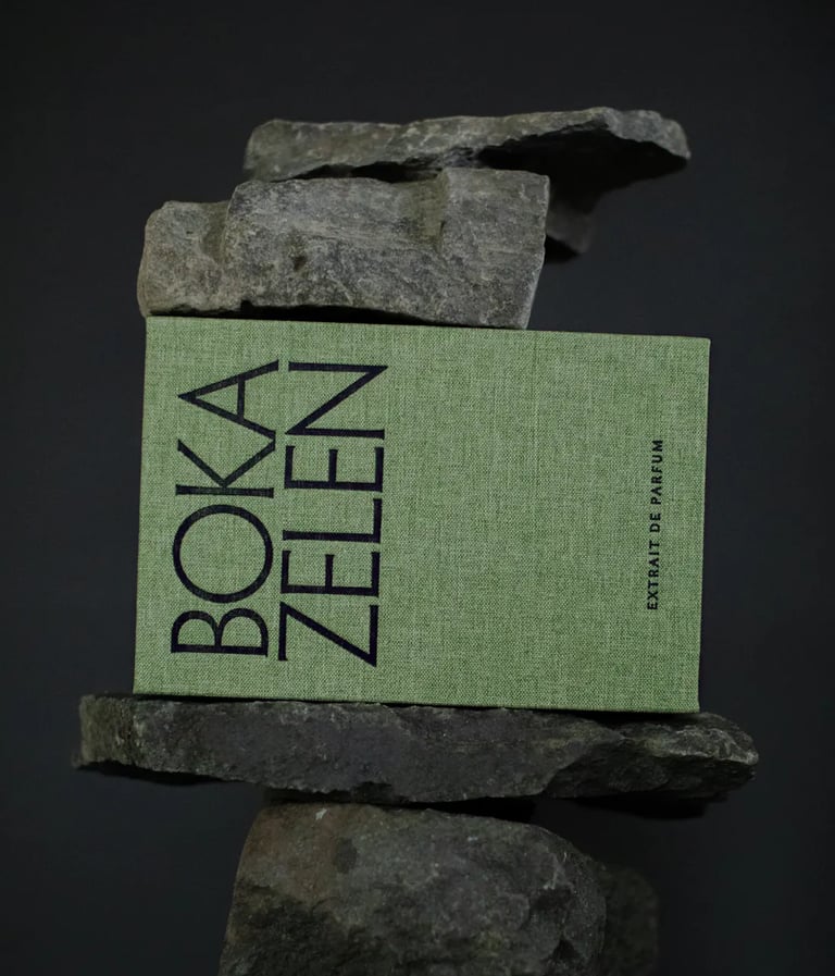 a box of boka fragrance with a bookmark on it and a stack of rocks