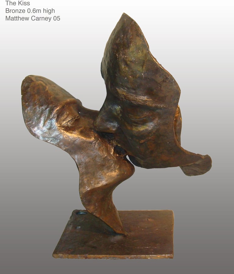 a bronze sculpture of two faces kissing