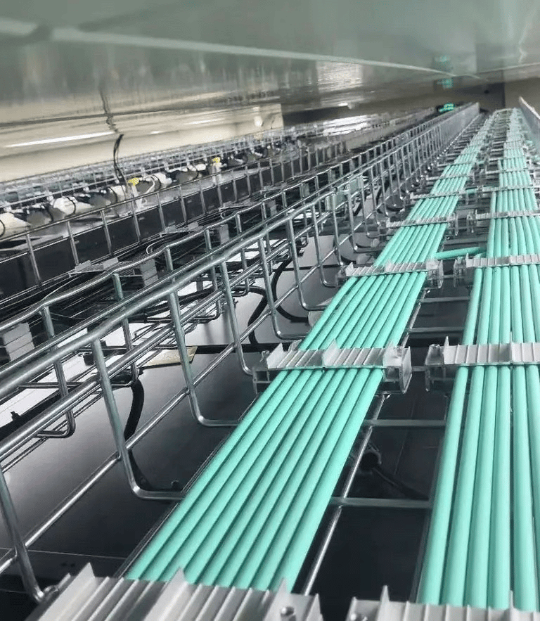 una bandeja de cables de malla de alambre con cables verdes y fijador de cables