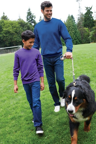 a man and a boy walking a dog on a leash
