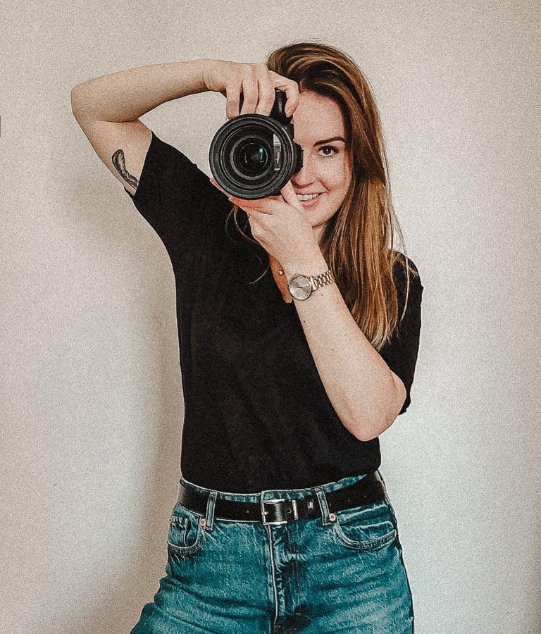 a woman taking a selfie with a camera and holding a camera