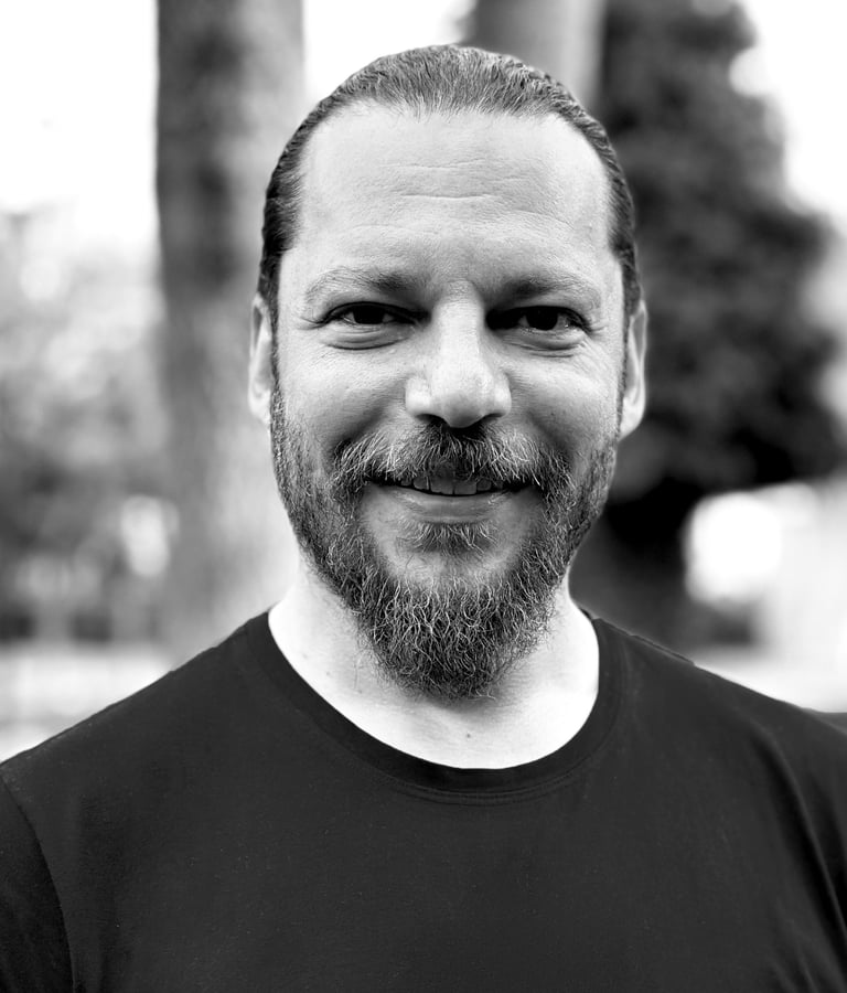 Alper Sümengen Tai Ji Qi Gong and sword instructor of WDP Turkey, smiling outdoors in black shirt