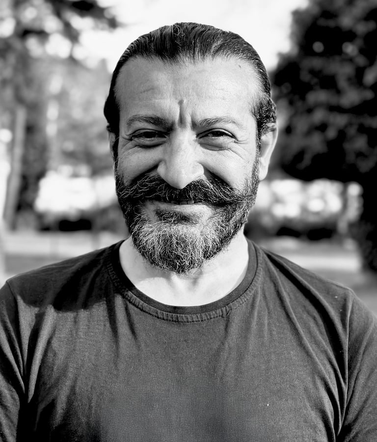 Mehmet Başkak, Tai Ji and Wudang Sword instructor of WDP Turkey, smiling outdoors in black shirt.