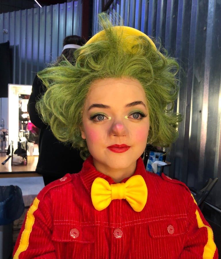 A character from a production displaying theatrical makeup  