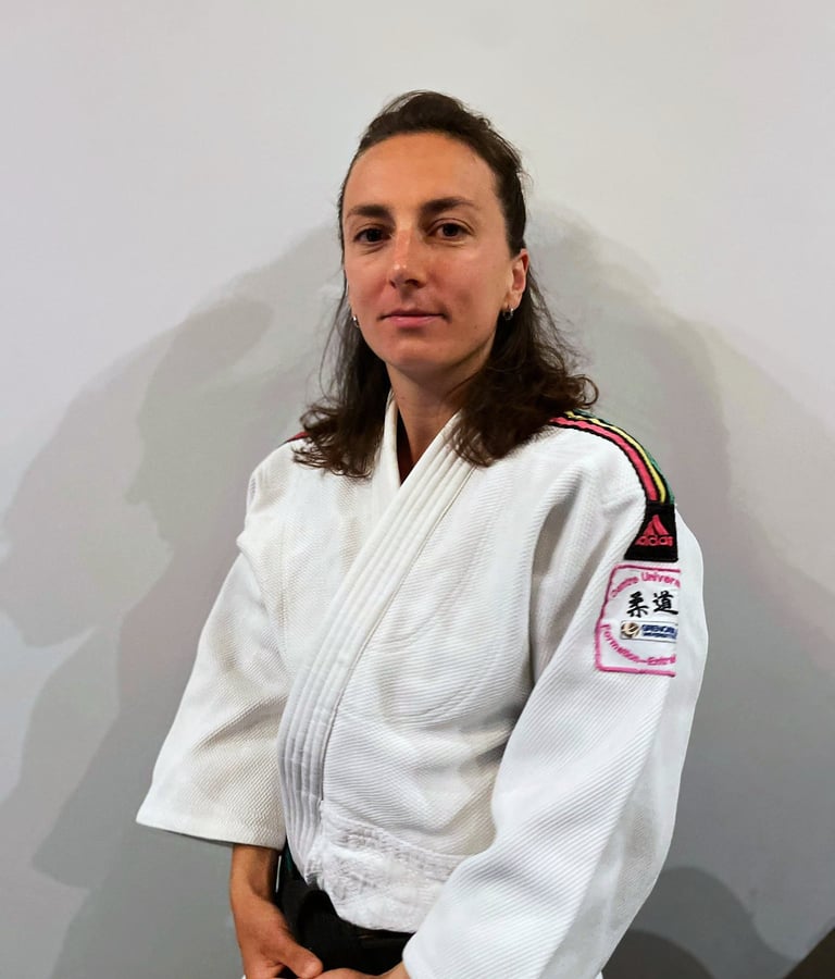 Une femme en kimono de Judo, portant une ceinture noire.