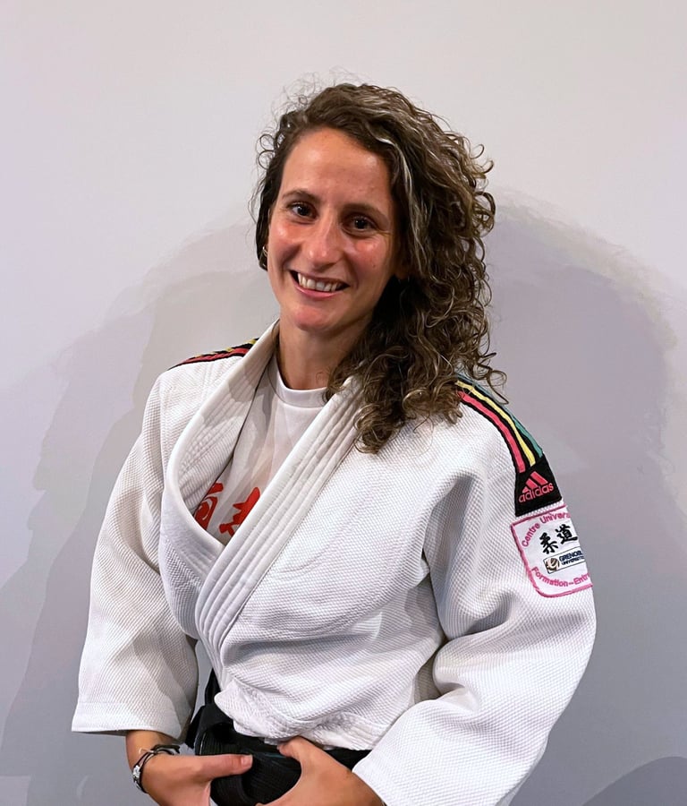 Une femme en kimono de Judo, portant une ceinture noire.