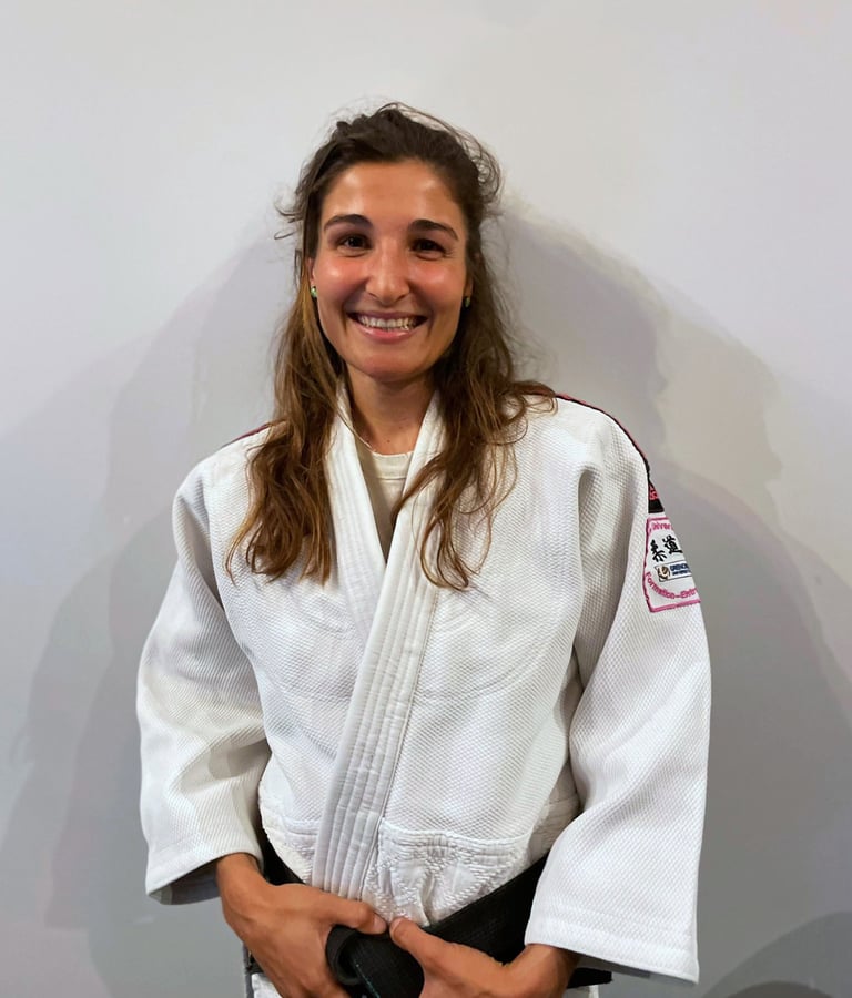 Une femme en kimono de Judo, portant une ceinture noire.