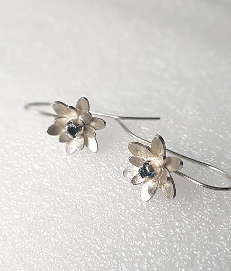 a pair of earrings with a flower design