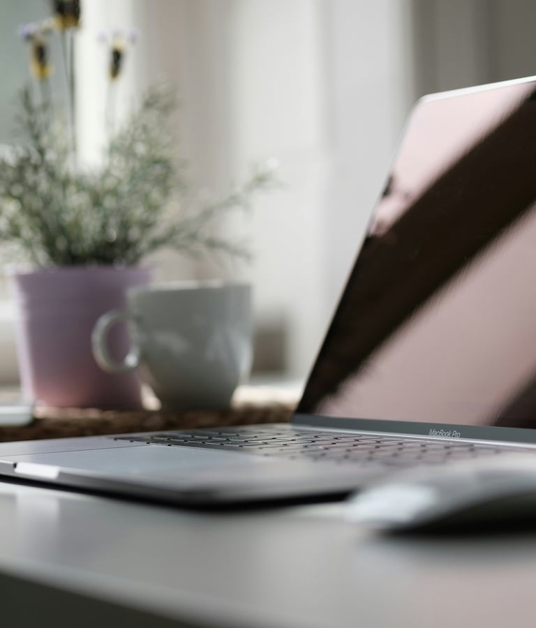 A designer's desk with a MacBook and a cup of coffee.