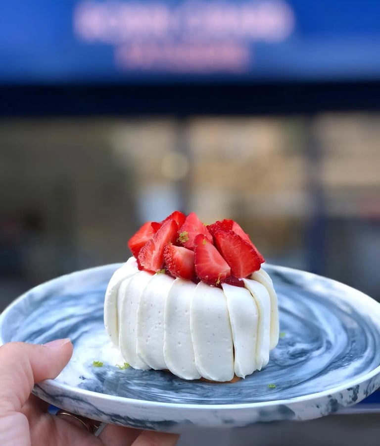 un délicieux fraisier dans une jolie assiette devant Robin Girard Pâtisserie