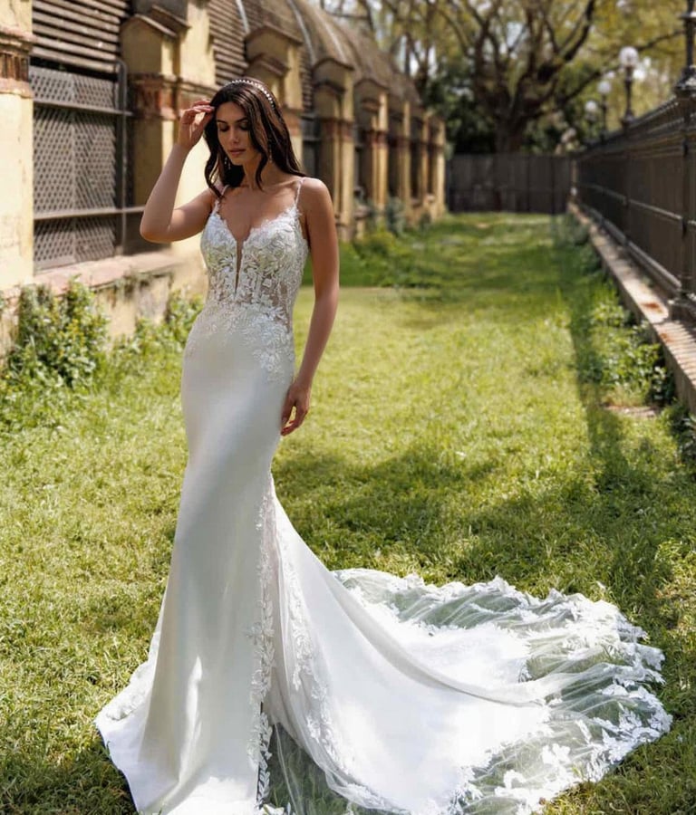 a woman in a white dress standing in the grass