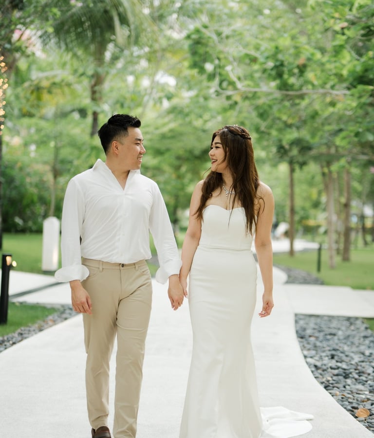 Couple walking together along a tropical garden path during a prewedding session at Apurva Kempinski Bali