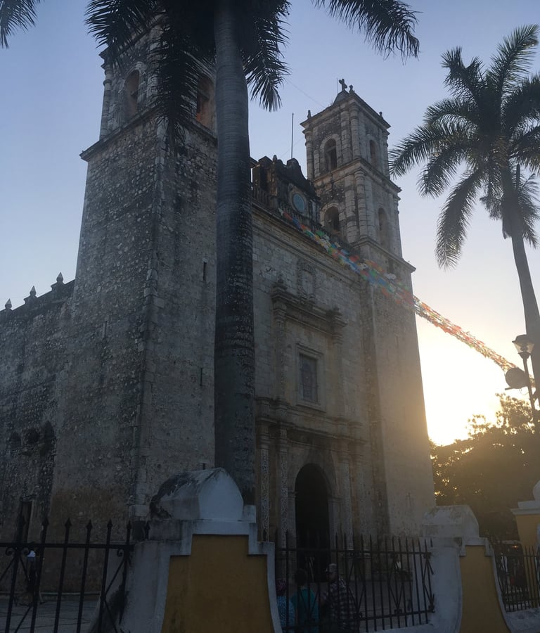 a church with a tall tower with a clock tower in the background