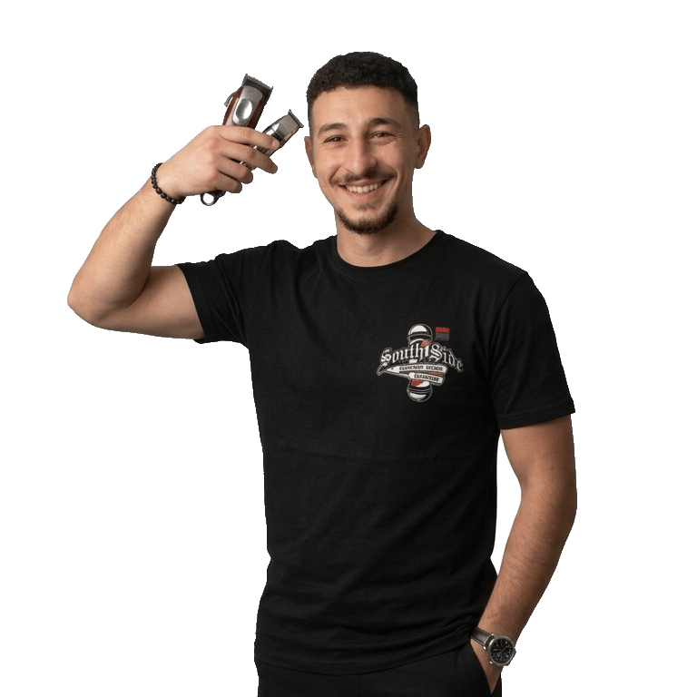 Smiling male barber in a black t-shirt holding professional hair clippers and grooming tools.