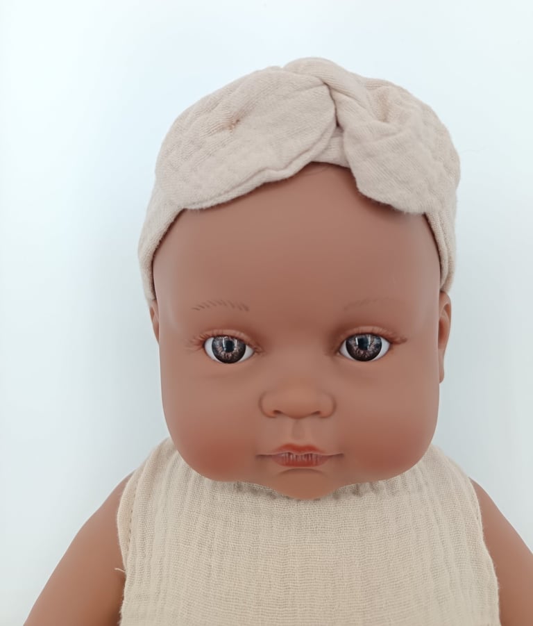 Close up of Minikane toddler doll with brown eyes
