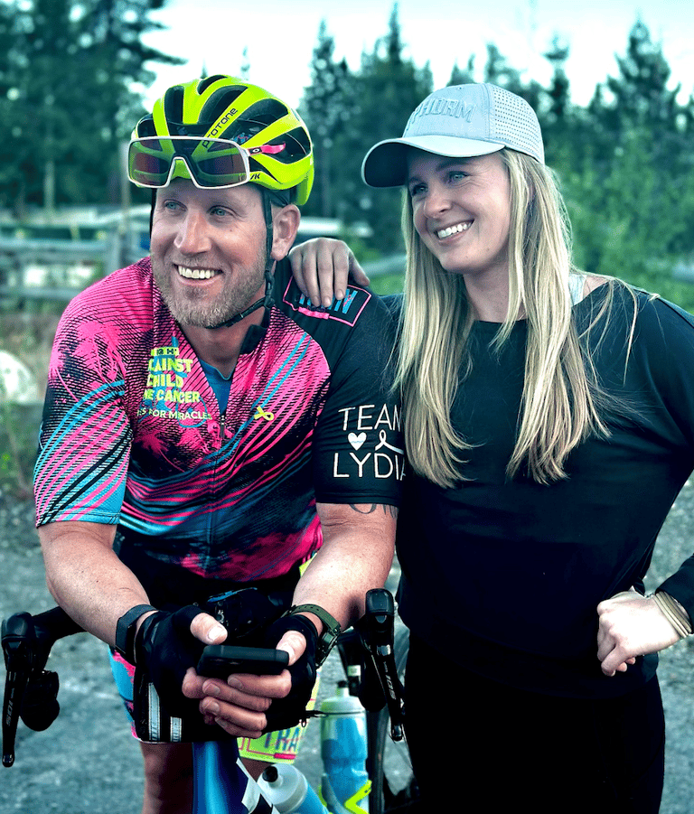 A picture of me (Justin) wearing cycling gear posing with another person (woman).