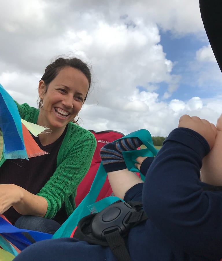 a woman sitting in a hammock with a baby