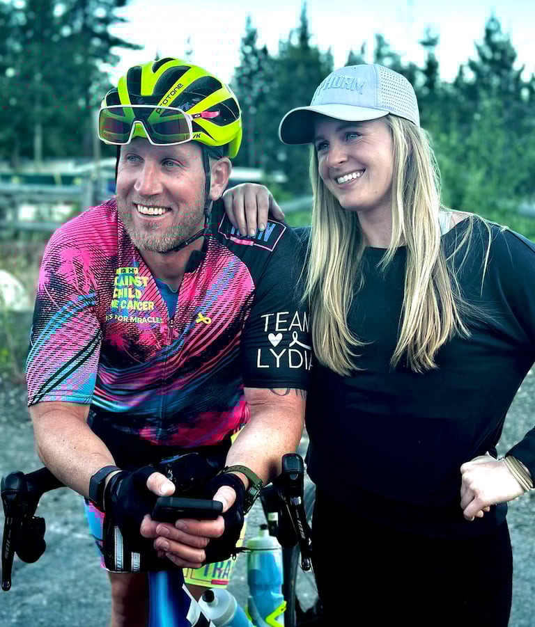 A picture of me (Justin) wearing cycling gear posing with another person (woman).