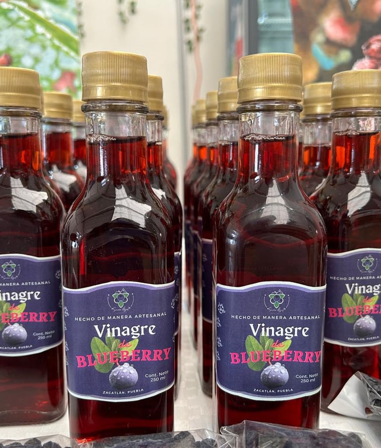 Botellas de vinagre de arándanos artesanales con tapas doradas exhibidas en filas en un mercado loca