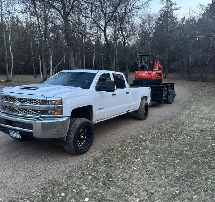 truck pulling trailer with excavator.
