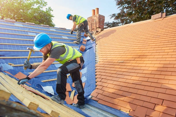 2 roofing workers installing orange tiles