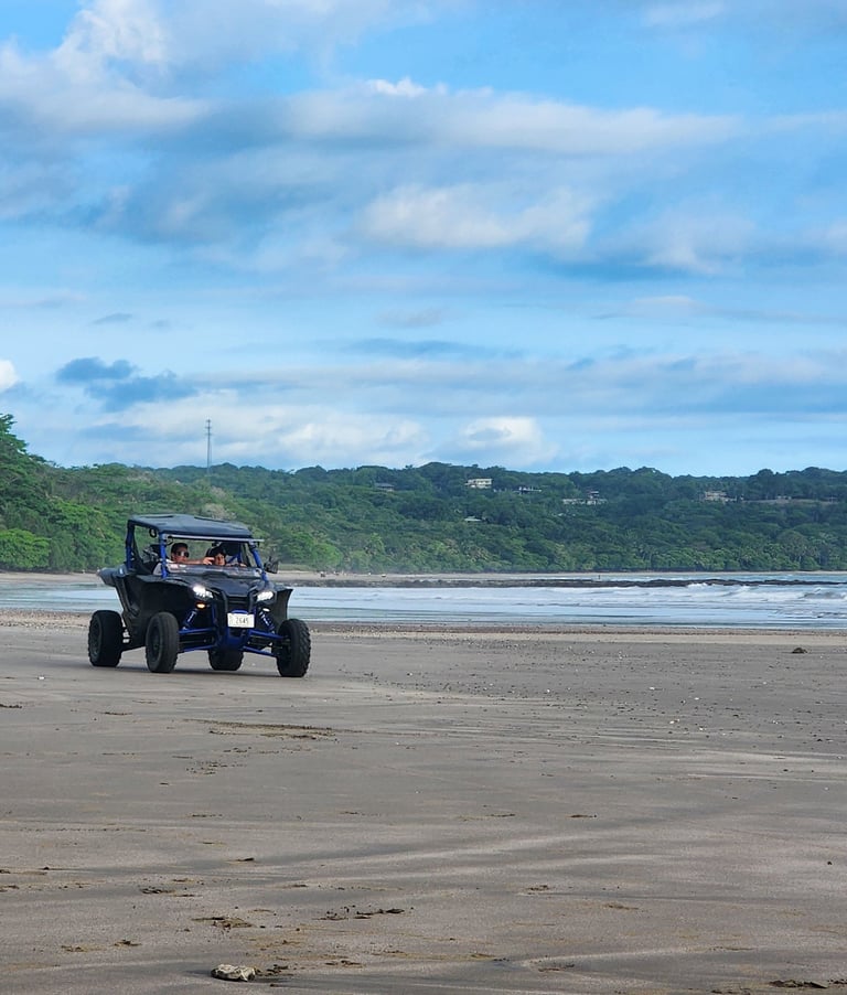 two people riding atvs on a beach