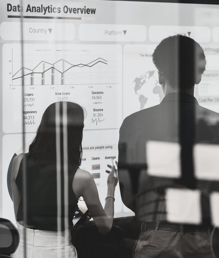 a group standing in front of a white board discussing a slide titled Data Analytics Overview