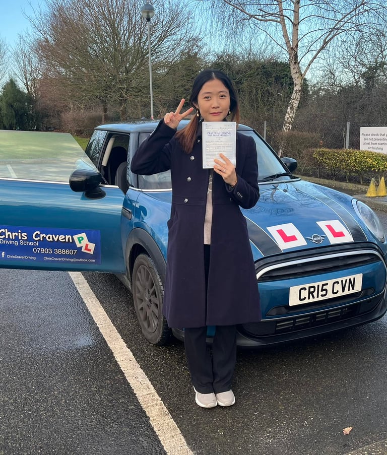 A girl standing in front of a mini cooper owned by Chris Craven Driving School