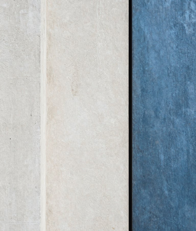 Photography of raw architectural textures. A contrast between rough off-white concrete and smooth slate blue metal. Minimalist, abstract composition, European aesthetic.